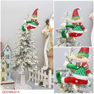 Detailed view of Christmas elf plush doll hanging on a snowy tree with sequin red hat