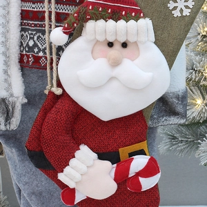 19.7in burlap Christmas stocking with 3D Santa holding a candy cane hanging on a lit tree