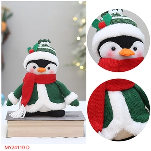 Gros plan d'un pingouin en peluche avec pull en tricot et écharpe rouge pour Noël