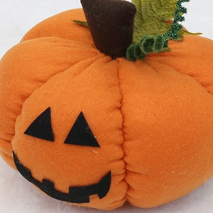 Halloween plush pumpkin decor with spooky face and green leaf for festive party ornament