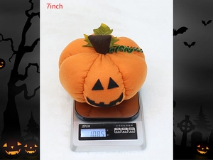Detailed view of 7-inch plush Halloween pumpkin with spooky face on a digital scale