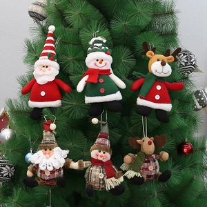 Detail of six Christmas plush ornaments including Santa and reindeer on a green tree