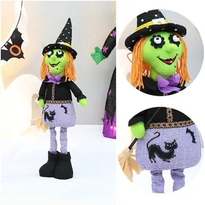 Detail of Halloween witch doll with green face, orange hair, and pointed hat with broom