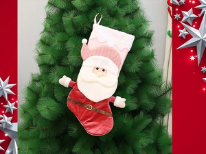 Close-up of 3D Santa plush Christmas stocking with pink faux fur trim on a green tree