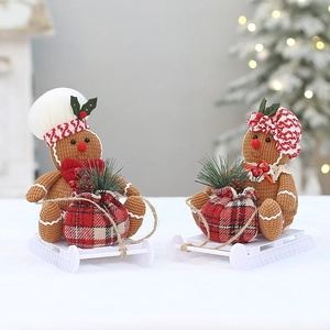 Detail of gingerbread man dolls on a white sleigh with festive holiday decorations