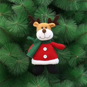 Detail of plush reindeer Christmas ornament with red knit sweater on green tree
