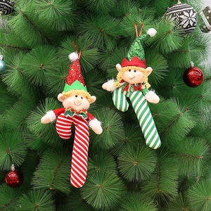Christmas elf plush ornaments with striped legs and sequined hats on a festive pine tree