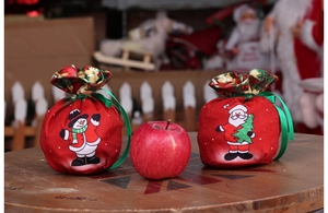 Christmas drawstring candy bags with Santa and snowman patterns on wooden table
