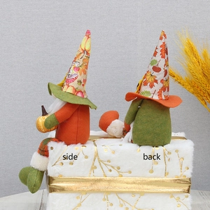Detail view showing side and back profiles of autumn gnome plush dolls with maple patterns