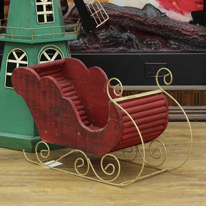 Rustic red wooden Christmas sleigh ornament with shimmering gold metal runners for decor