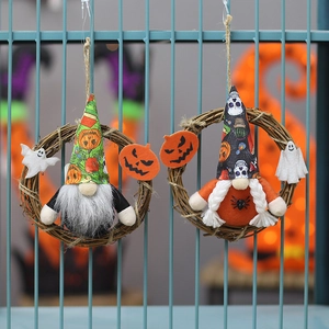 Detail von zwei Halloween-Wichtelkränzen mit Kürbis- und Totenkopfhüten auf Weidenringen
