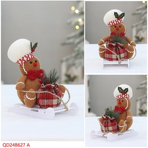 Three-view detail of knitted gingerbread man with chef hat on white sleigh base