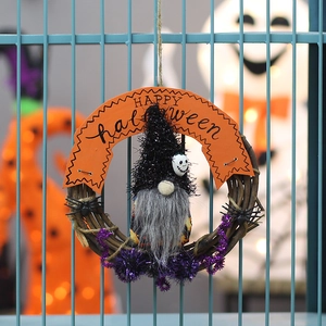 Halloween wreath with gnome, black spiders and Happy Halloween banner on rustic fence
