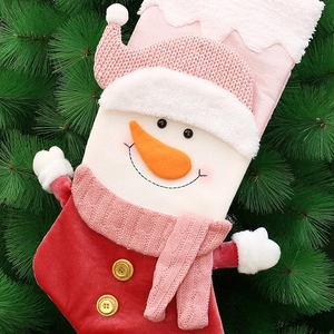 Christmas snowman stocking decoration with pink knit hat and red velvet body hanging on a tree