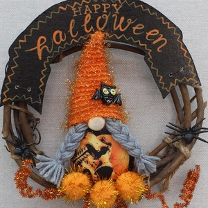 Detail of Halloween gnome wreath with plush bat hat and fuzzy spiders on vine base