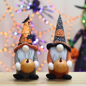 Close-up of Halloween plush gnomes with spider web hats holding small pumpkins decor