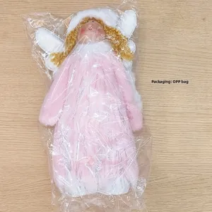 Close-up of pink plush Christmas angel doll with silver accents and golden hair