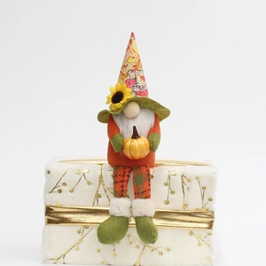 Fall Harvest Gnome plush with sunflower hat holding a pumpkin on white gift box