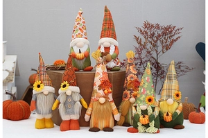 Group of autumn harvest gnomes with sunflowers, maple leaves, and small pumpkins