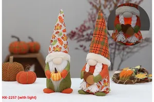 Detail of lit fall gnomes with maple leaf hat and pumpkin for harvest decoration