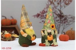 Close-up of Thanksgiving faceless gnomes with sunflower hats and orange pumpkins