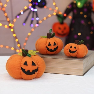 Three plush orange Halloween pumpkins with jack-o'-lantern faces for party decor