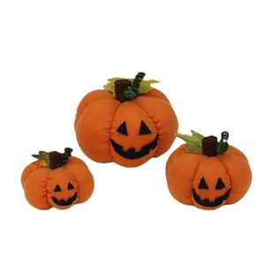 Three plush orange Halloween pumpkins with black Jack-o'-lantern faces for party decor