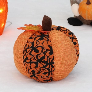 Detail of orange burlap Halloween pumpkin decoration with black spider web pattern and maple leaf