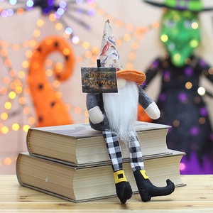 Halloween faceless gnome doll with long legs and Happy Halloween sign on a desk