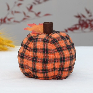 Close-up of orange plaid fabric pumpkin with brown stem and autumn maple leaf detail