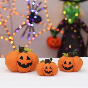 Three sizes of orange Halloween plush pumpkins with jack-o-lantern faces for party decor