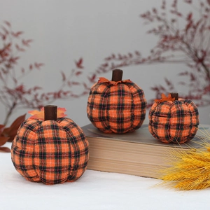 Three plaid fabric pumpkins of different sizes with maple leaves for autumn decoration