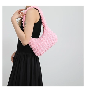 Détail du sac à bandoulière rose à texture bulles montrant le tissu bouffant 3D et le zip