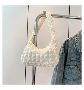 Détail du sac blanc à texture pop-corn avec design plissé 3D sur un support en métal