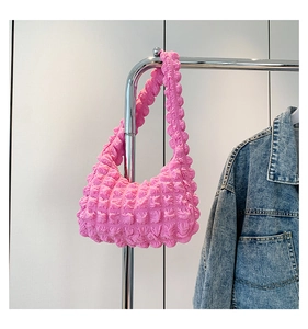 Détail du tissu à texture bulles rose sur un sac à bandoulière froncé pour femme