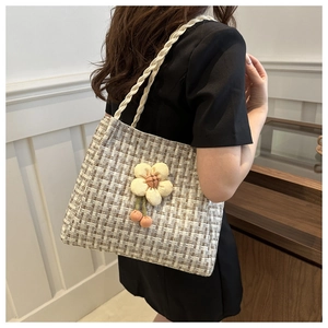Dettaglio della borsa tote in tweed con fiori 3D e ciliegie sul manico intrecciato