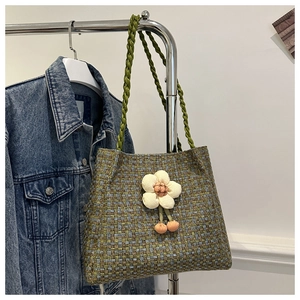 Dettaglio della borsa tote in tweed verde con fiore 3D e manici in corda rustica