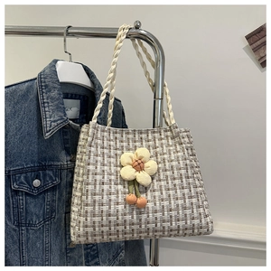 Dettaglio della borsa tote tessuta a quadretti grigi con fiori 3D e ciliegie