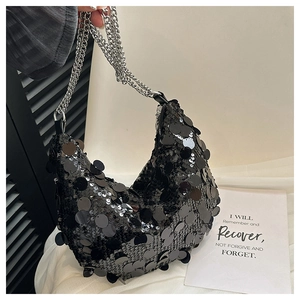 Close-up of black sequins texture and silver metal chain strap on a trendy evening bag