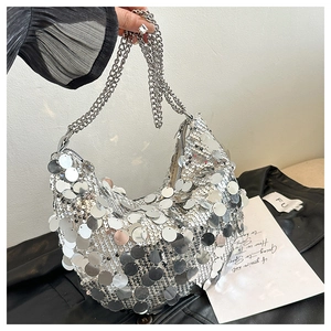 Detailed macro view of silver sequin crescent handbag with shiny metal double chain handles