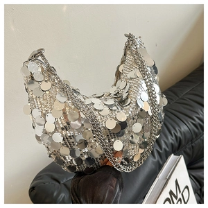 Macro detail of silver oversized sequins and chunky metallic chain on a crescent bag