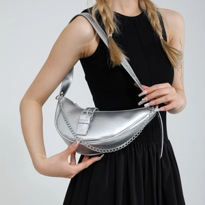 Sac hobo croissant argenté métallisé avec chaîne et style Y2K porté par un modèle