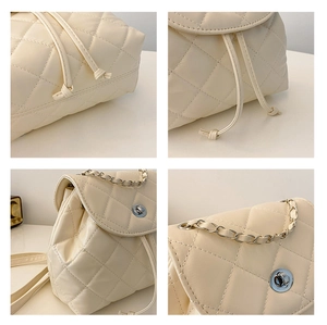Detail view of cream quilted bag with diamond stitching, chain strap and turn-lock closure