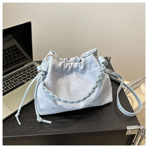Détail du sac seau plissé bleu clair avec poignée tressée et fermeture à cordon
