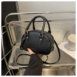 Détail d'un sac bowling noir en similicuir avec garnitures argentées et poignées