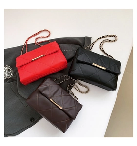 Detailed shot of quilted crossbody bags in red, black, and brown with gold chain straps