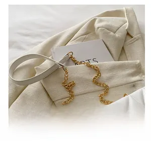 Close-up of quilted white shoulder bag featuring gold chain strap and metal hardware