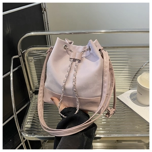 Detail of pink drawstring bucket bag with chain strap and contrast bottom panel