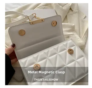 Detail of the white quilted crossbody bag showing the magnetic clasp and stitching