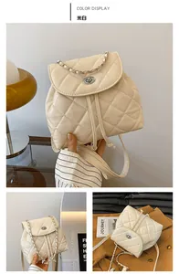 Detail view of cream quilted mini backpack with chain straps and metal twist lock closure
